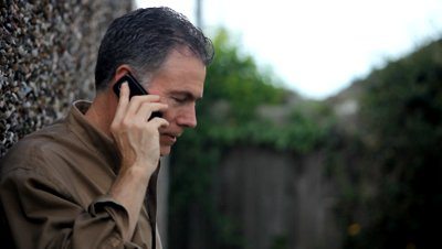 stock-footage-a-man-outside-using-wireless-service-to-chat-with-someone-via-his-cell-phone