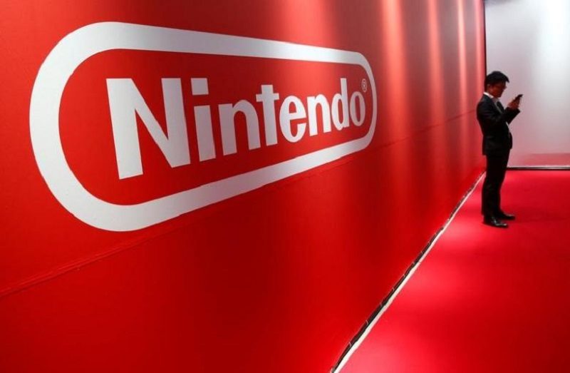 A man stands in front of Nintendo's logo at the presentation ceremony of its new game console Switch in Tokyo